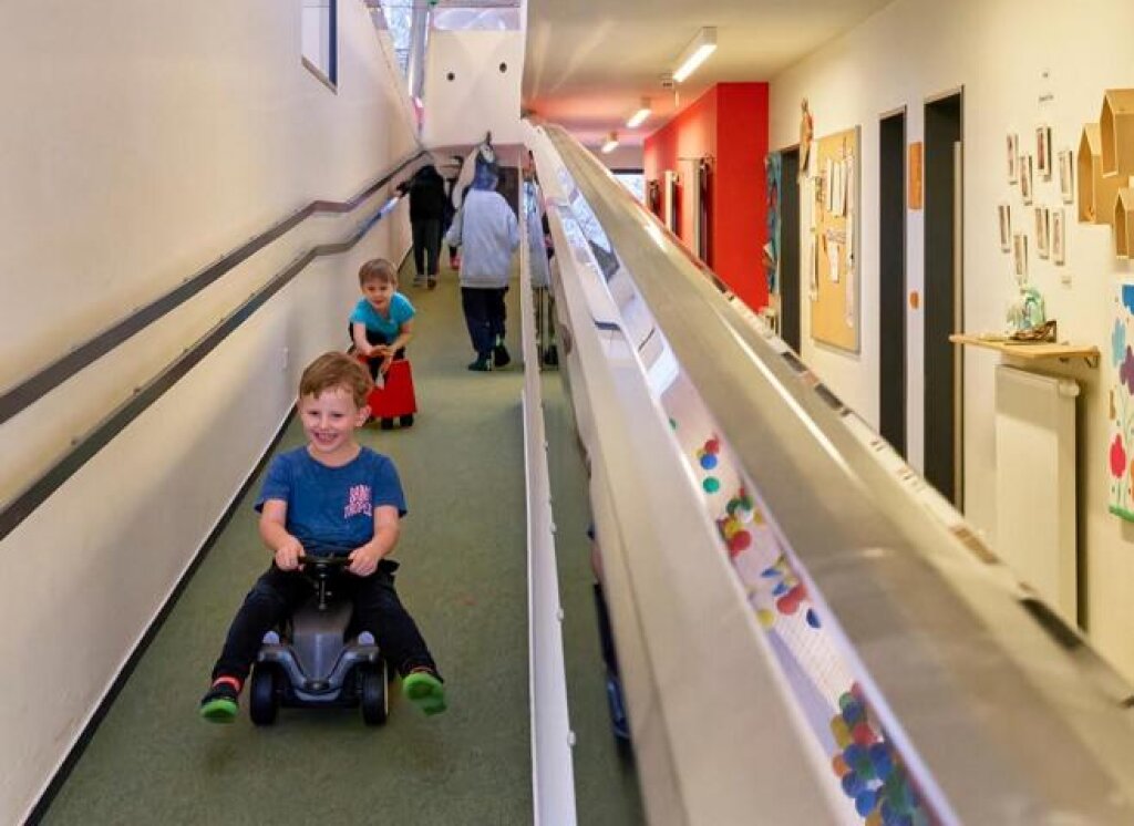 AWO Kita Huulkamp Lehmsal Kind fährt den langen Flur mit BobbyCar.