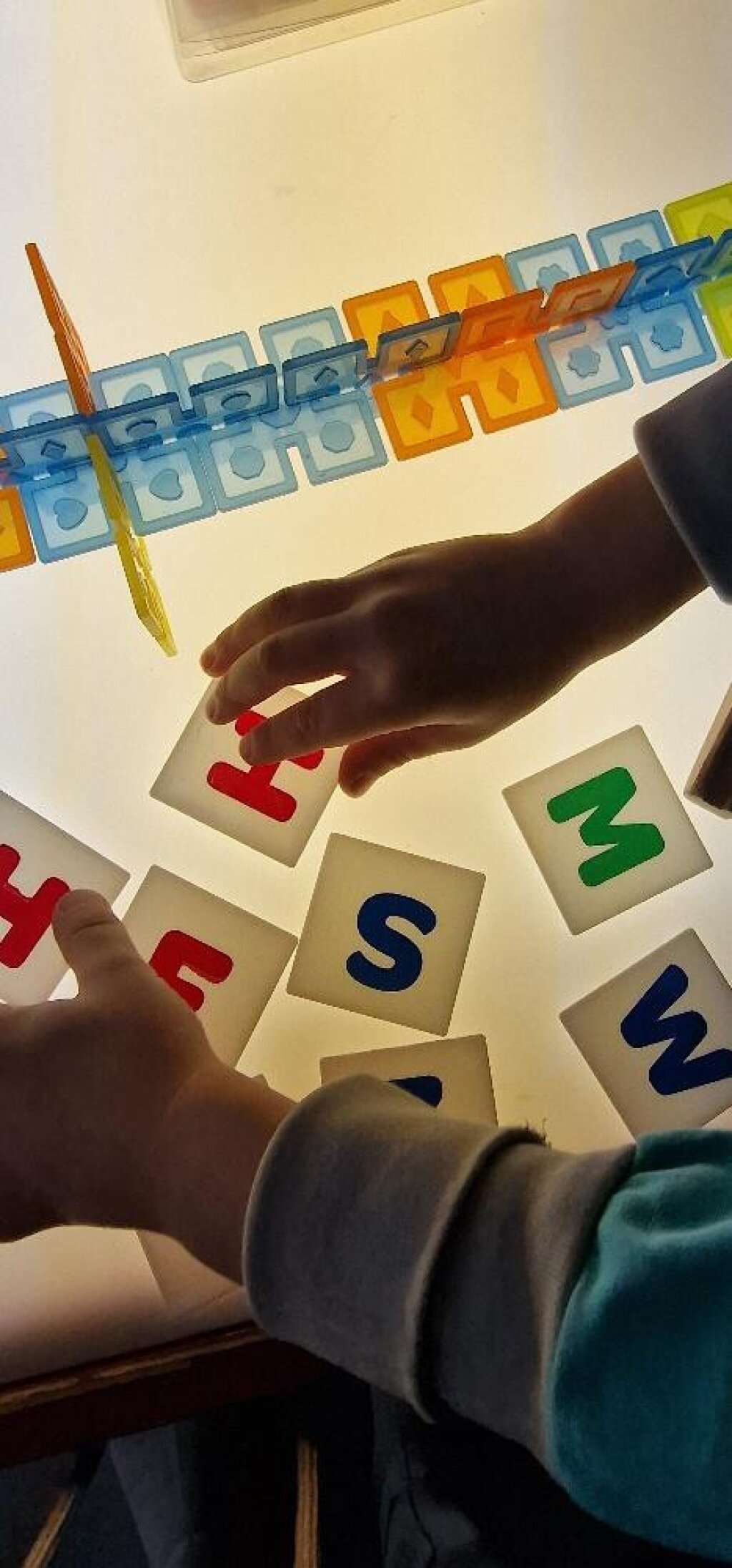 Kinderhände mit Buchstaben.